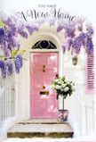 This doorway scene in Petts Wood feels like a quiet, cinematic moment paused on the edge of a fresh start. A pale pink front door, painted in a soft, almost chalky blush, stands at the heart of the image, bordered by a slim shutter in the same gentle shade and walls washed in warm white. Overhead, wisteria spills down in romantic cascades of lavender and dusky lilac, the blossoms hanging in loose, fragrant tresses that seem to sway in an unseen breeze, much like the blooms that trail over garden fences near Petts Wood Recreation Ground in late spring. On the threshold itself, a rounded grey tin bucket holds a lush cluster of white and cream roses, their petals full and luxurious, curling outward in soft spirals that catch the light. Threads of subdued green foliage weave between the roses, creating a subtle halo of colour that grounds the bouquet and makes the ivory tones glow even more. A pink satin ribbon wraps around the base of the bucket, its sheen reflecting the door's colour and linking the entire composition in one calm, pastel chord. The light is neither harsh nor dim; it feels like late afternoon or early evening, when the day is winding down and the future feels wide open. The arrangement looks freshly delivered, perhaps by Flower Delivery Petts Wood for a housewarming on a side street off Queensway, carrying with it the unspoken wish that this new address will be filled with laughter, gentle mornings, and cherished memories from the very first step inside.